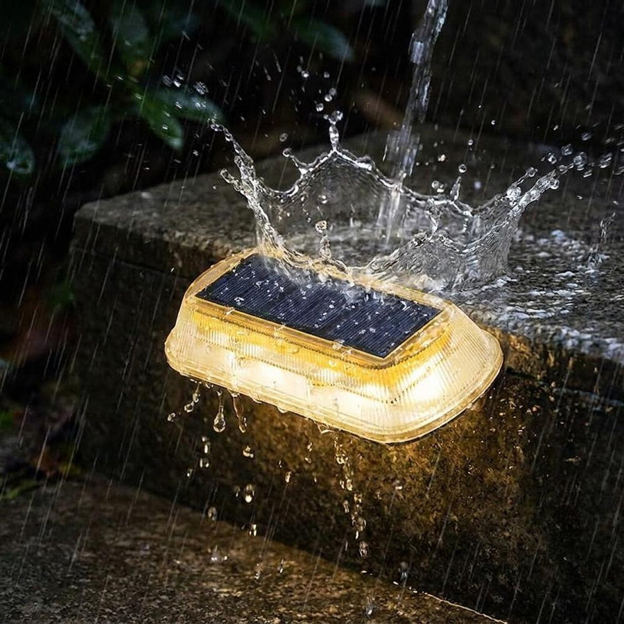 Solar step light glowing warm white in heavy rain waterproof