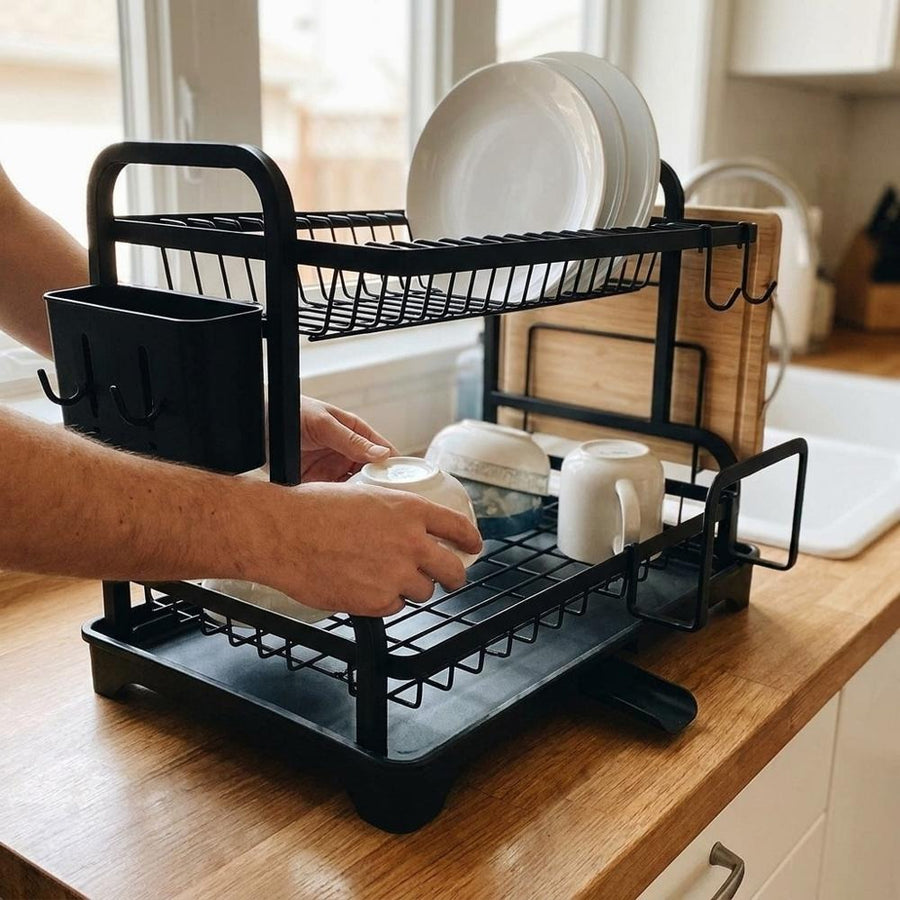 Person placing bowl into the 2-tier dish rack on wood counter