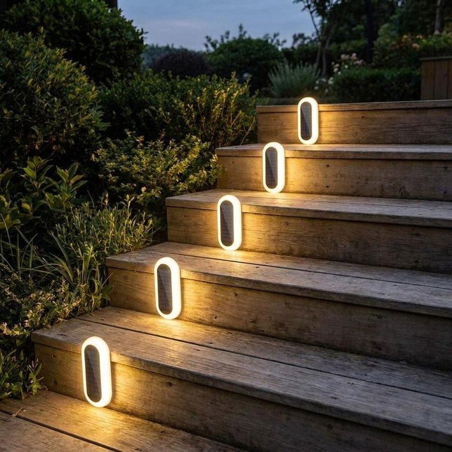 Solar stair lights glowing on wooden garden deck at dusk