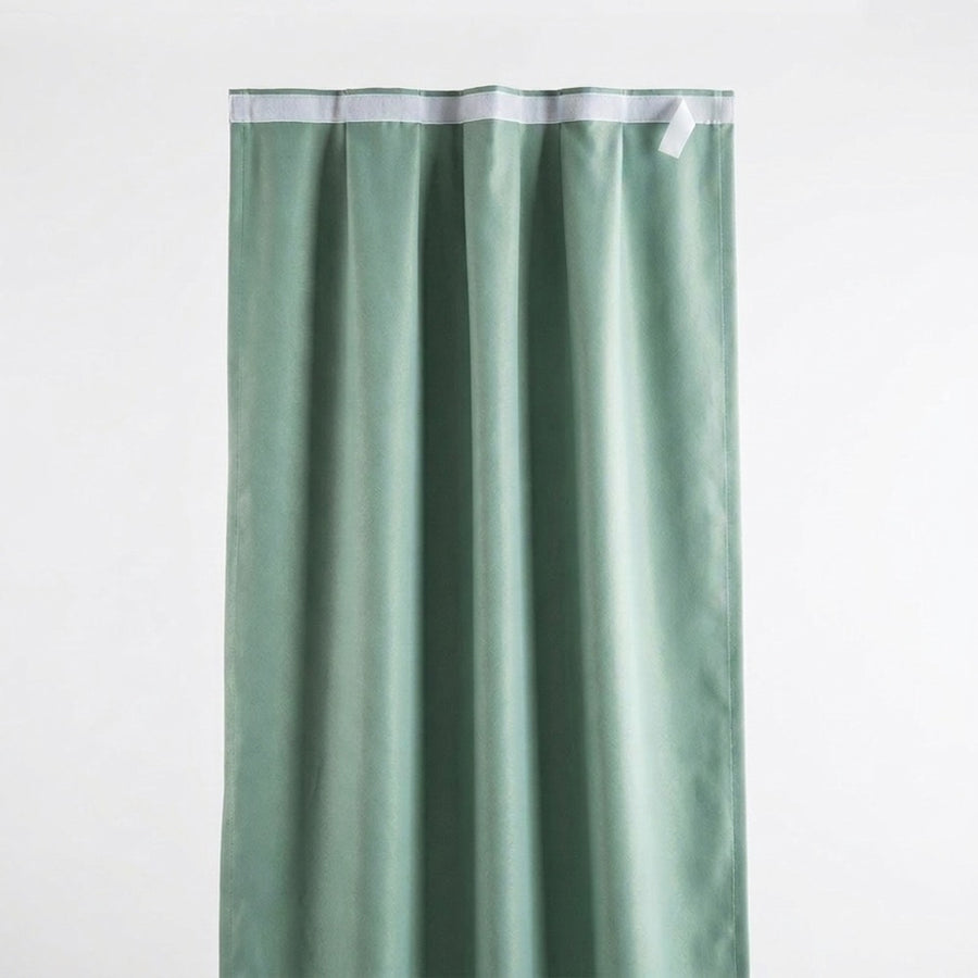 Self-adhesive blackout curtain panel in light green, adhesive strip at top