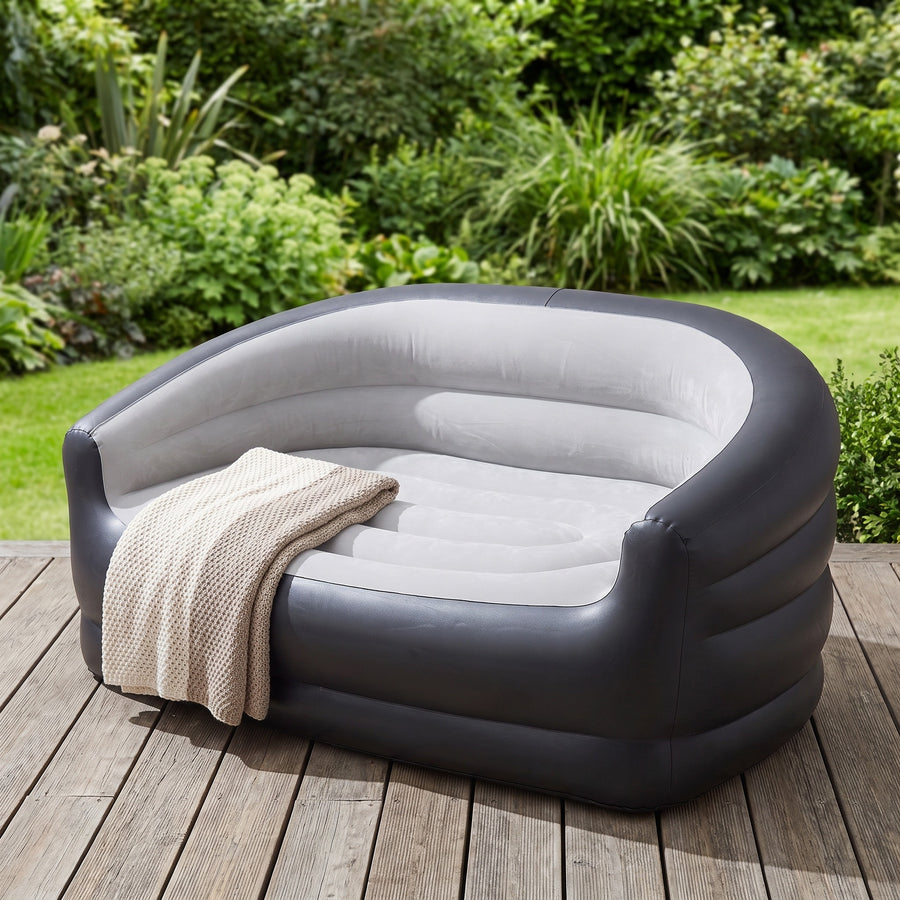 Inflatable sofa on wooden deck outdoors with garden background