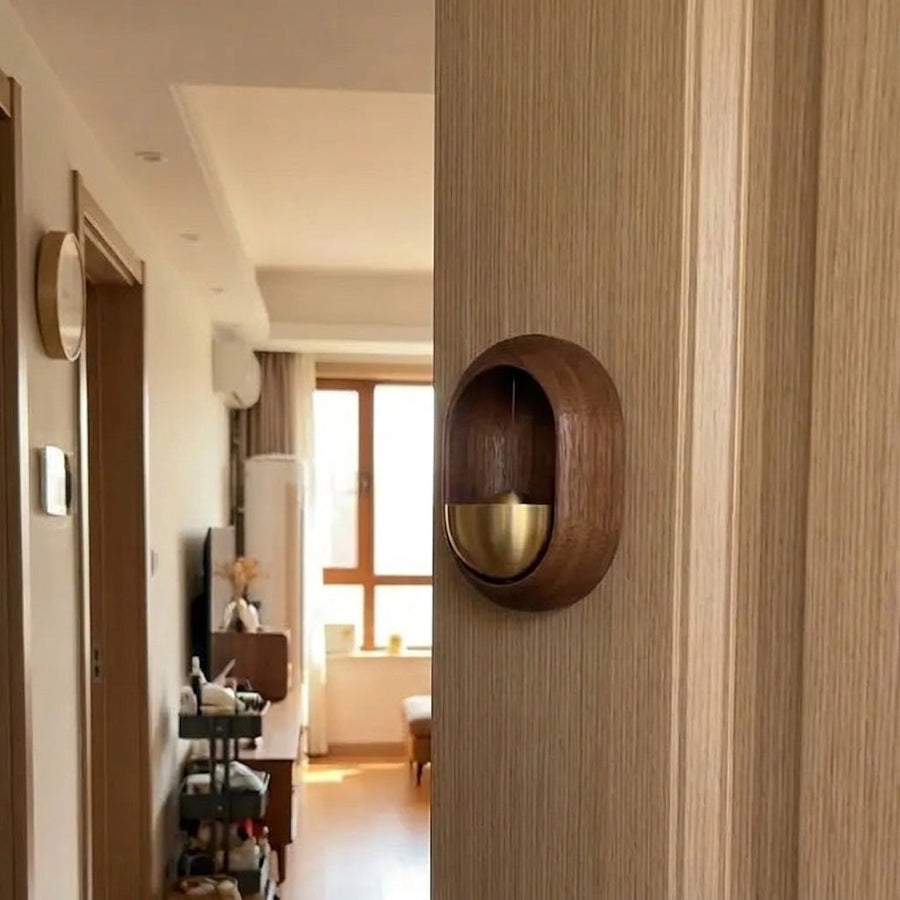 Oval walnut door chime mounted on a door frame at home