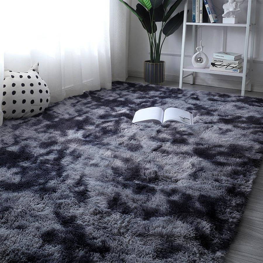 Dark gray tie-dye plush rug beside white shelf