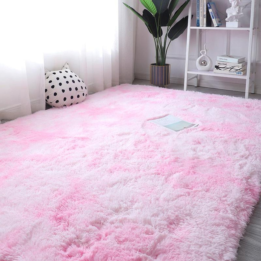 Pink tie-dye fluffy rug in white room setting