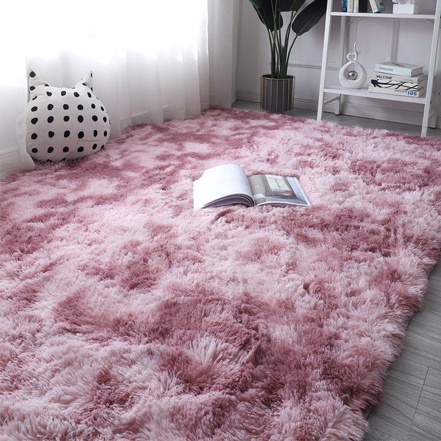 Mauve pink-purple gradient plush rug on floor