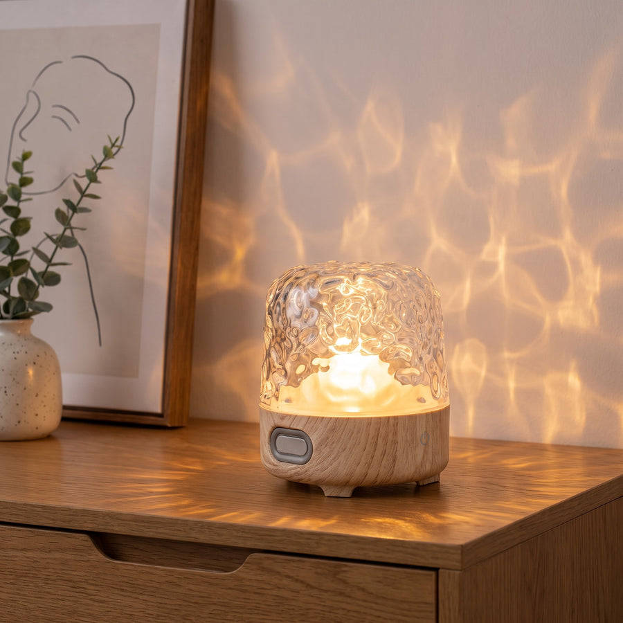 Havie Lamp with a light natural wood base glowing on an oak sideboard, casting water-ripple light on the wall