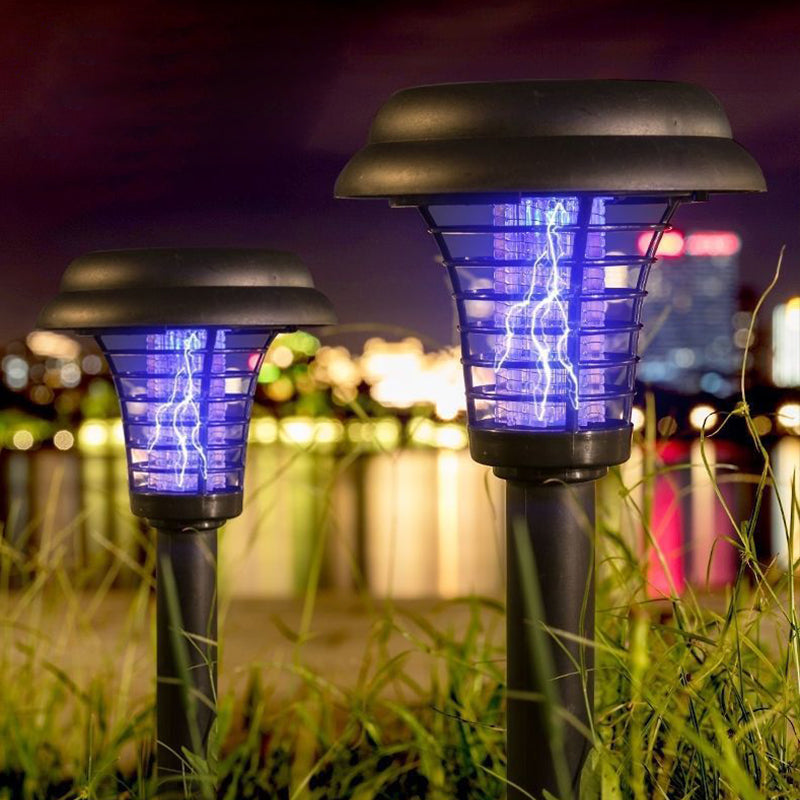 Solar insect killer with ground stake in a garden at night