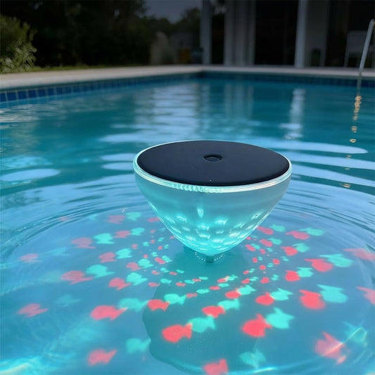 Floating pool light with fish projection in a pool at night