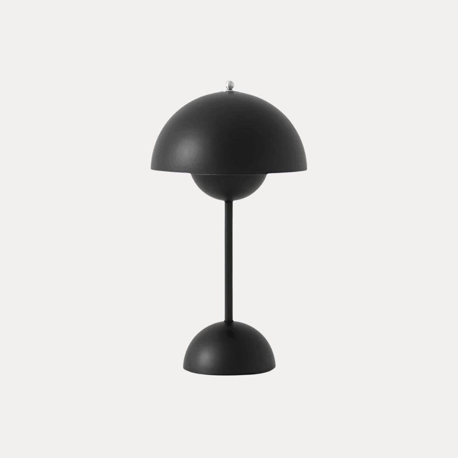 Matte black table lamp with dome shade on a neutral background