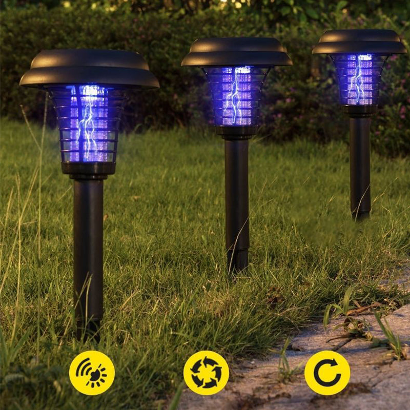 Three solar-powered insect killers on a lawn with UV glow