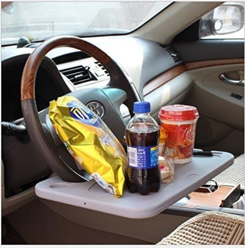 Gray steering wheel desk with food and a drink