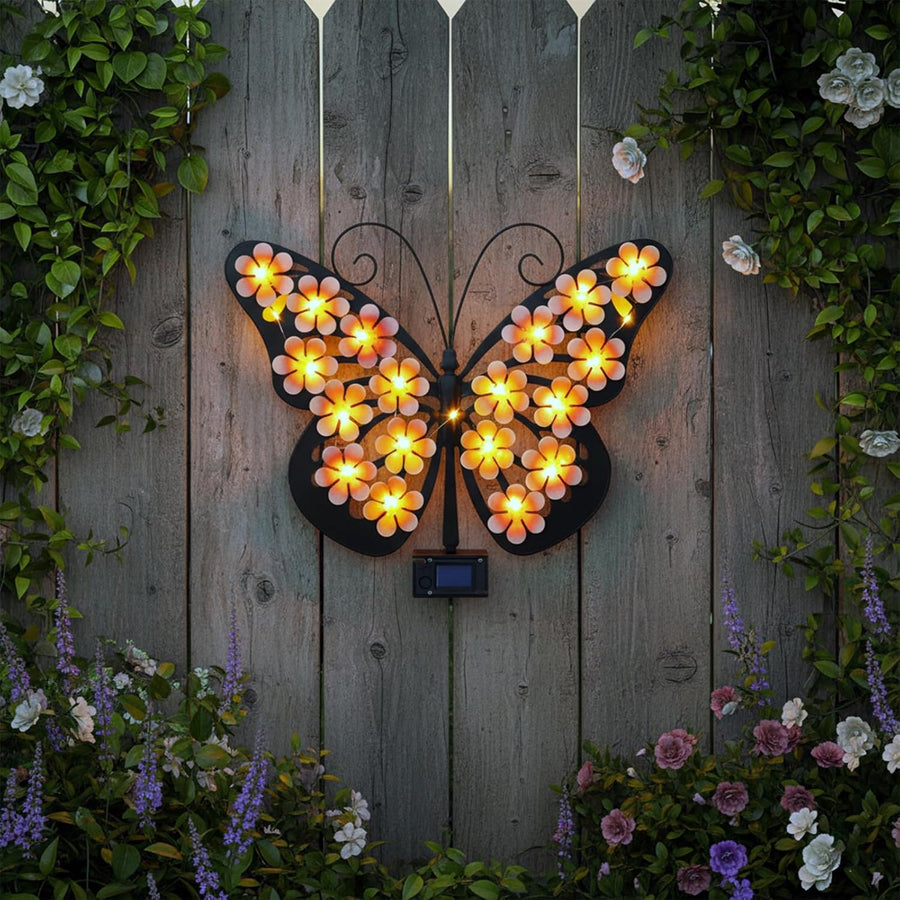 Metal butterfly with LED flowers on a wood fence – garden setting