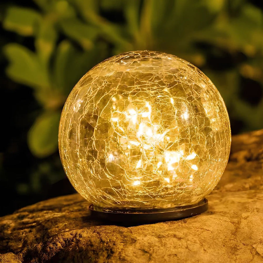 Close-up of a crackle glass solar globe on a stone
