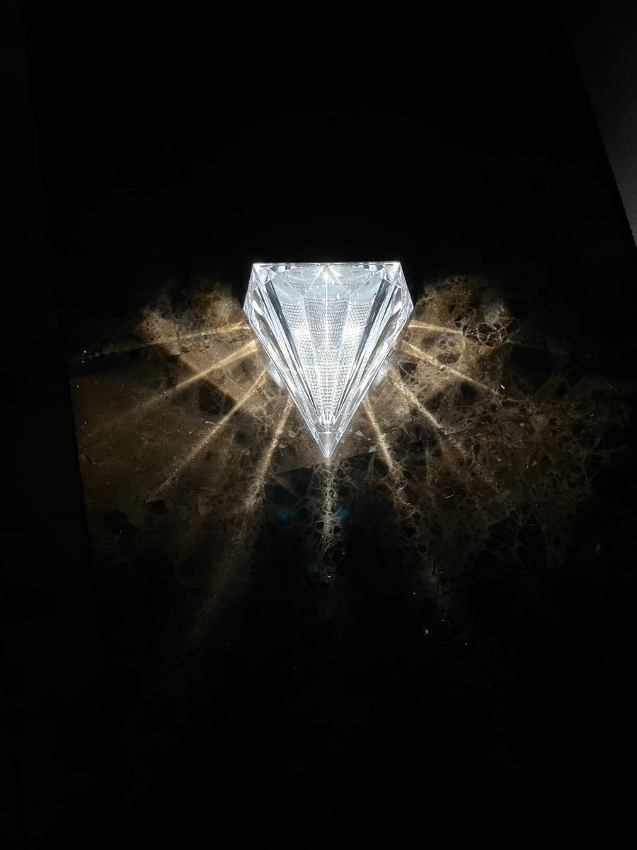 Diamond-shaped solar light glowing dramatically in the dark