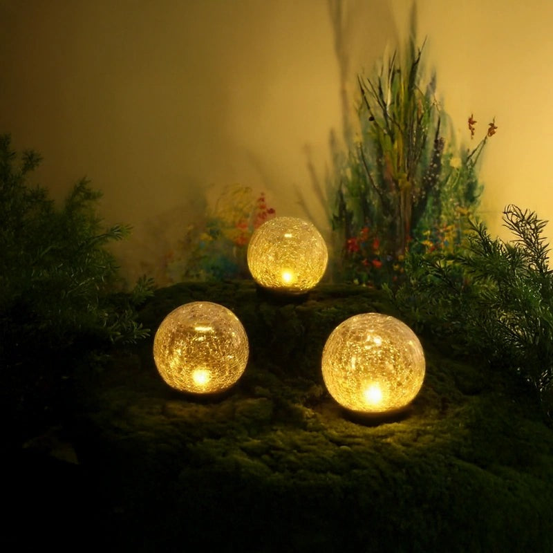 Three solar globes in a moss garden for outdoor lighting