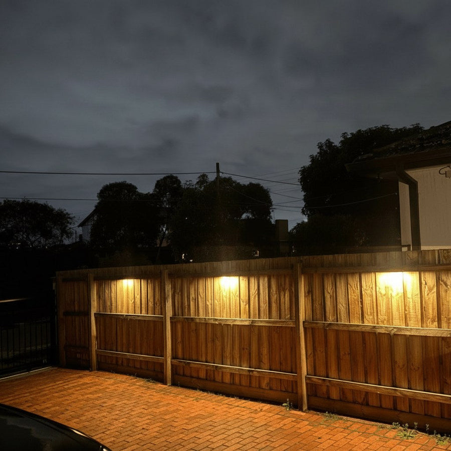 Three solar wall lights mounted on a fence