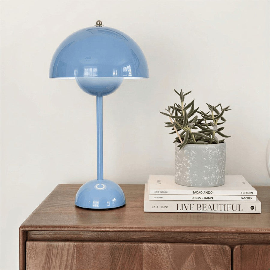 Rechargeable blue table lamp on a wooden side table with plants