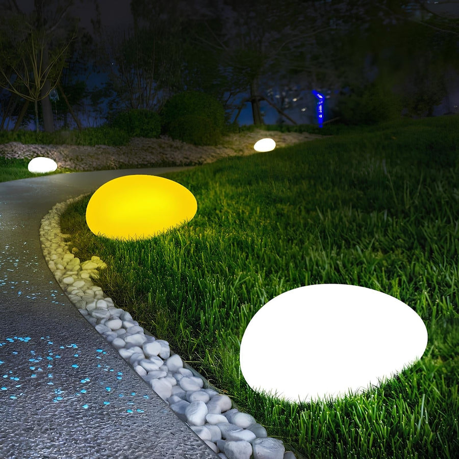 Stone-shaped LED garden lamp along a garden path at night