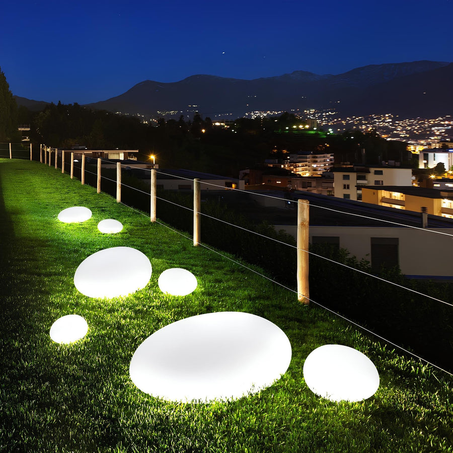 Garden stones with LED lighting along a fence with a city view