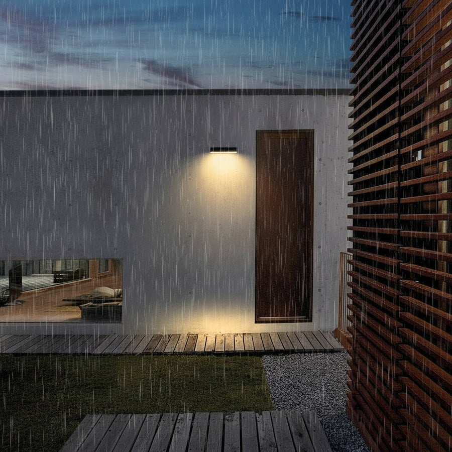 White solar wall light outdoors in the rain