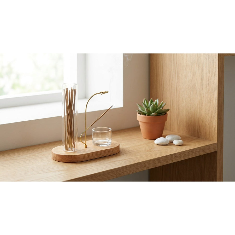 Incense holder set on Scandinavian wooden shelf with succulent plant and white pebbles