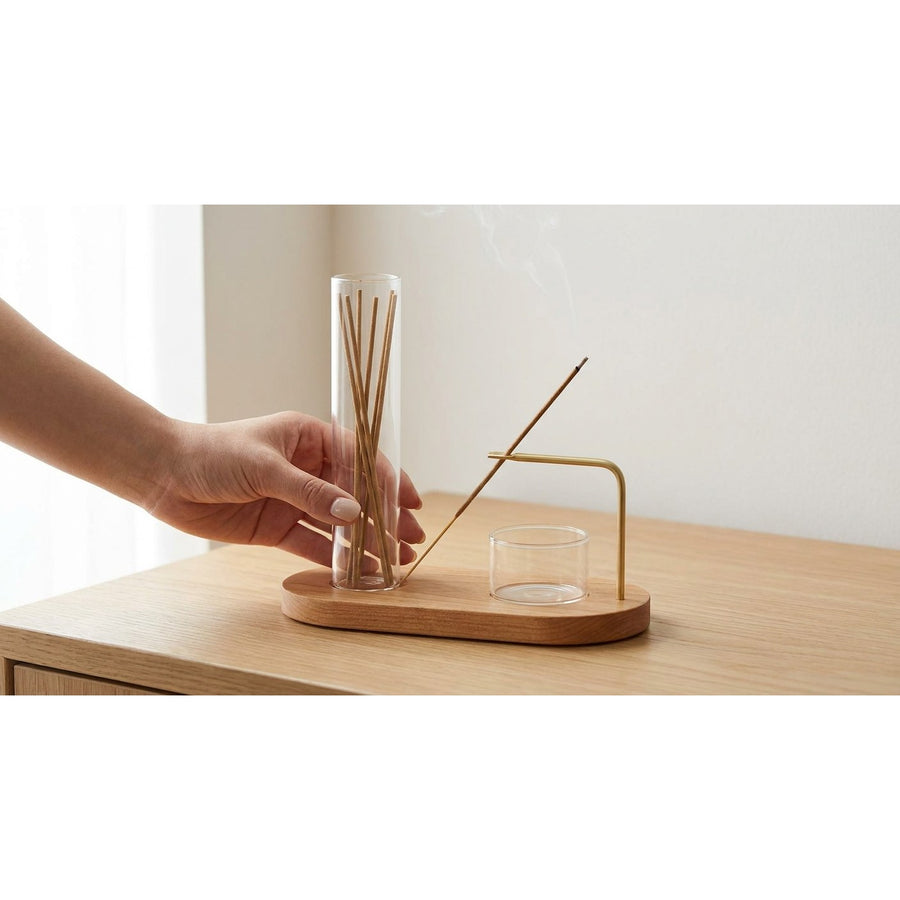 Hand placing incense holder set on wooden surface showing compact size