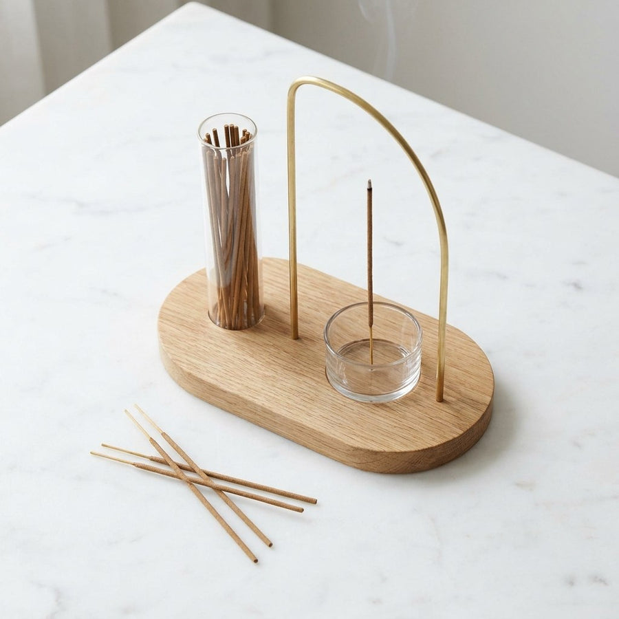 Top-down view of incense holder set on white marble surface with loose incense sticks