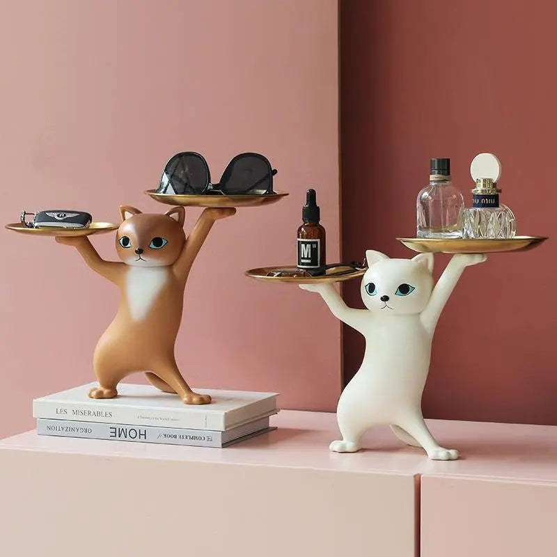 Brown and white cat figurines with accessories on the trays