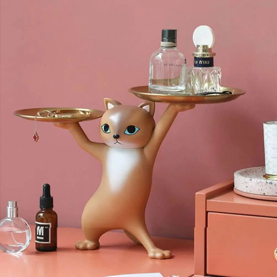 Brown cat figurine on a dresser with jewelry and perfume
