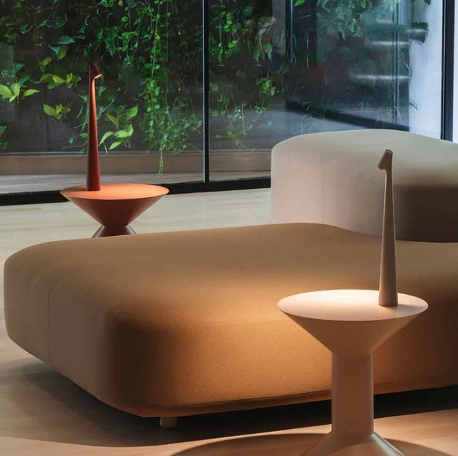 Minimalist LED table lamp next to a bed