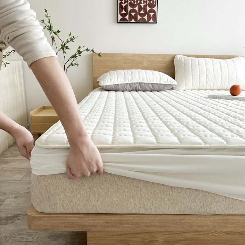 Quilted mattress cover folded and displayed on a shelf