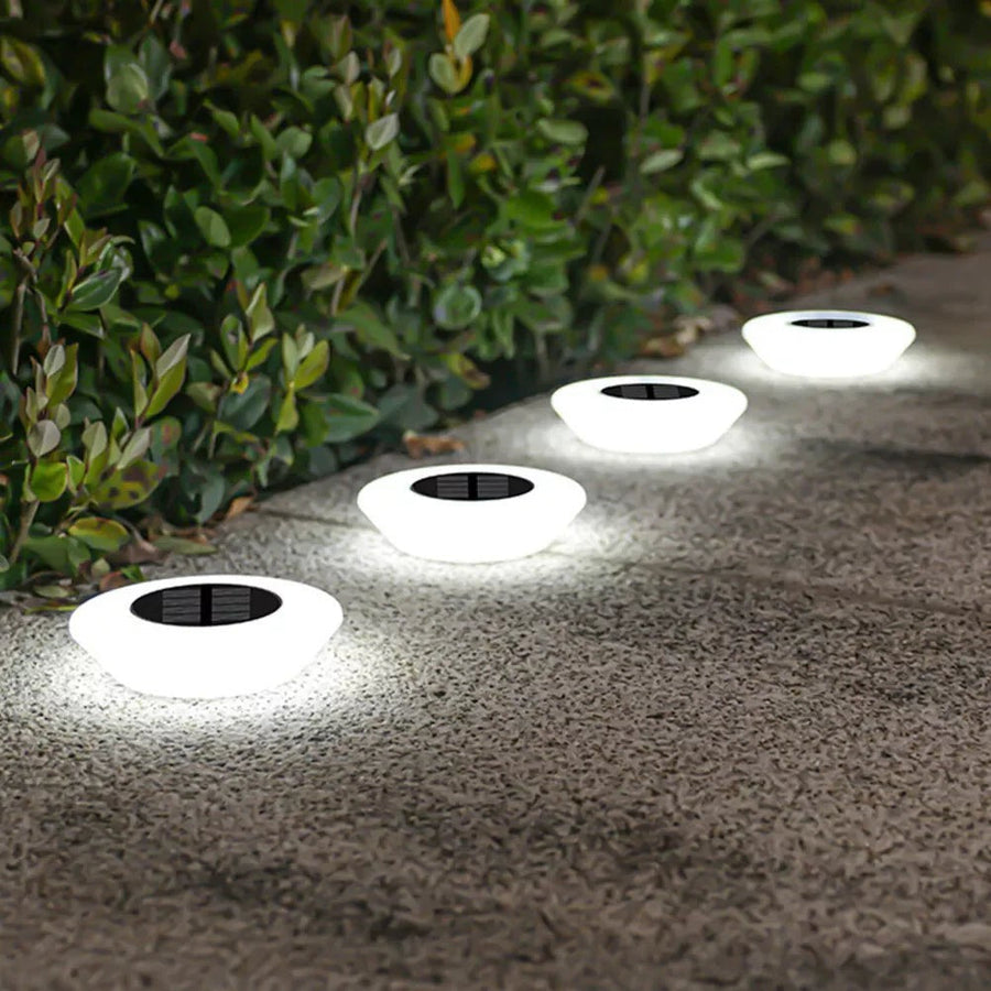 Solar-powered ground lights along a stone path in the garden