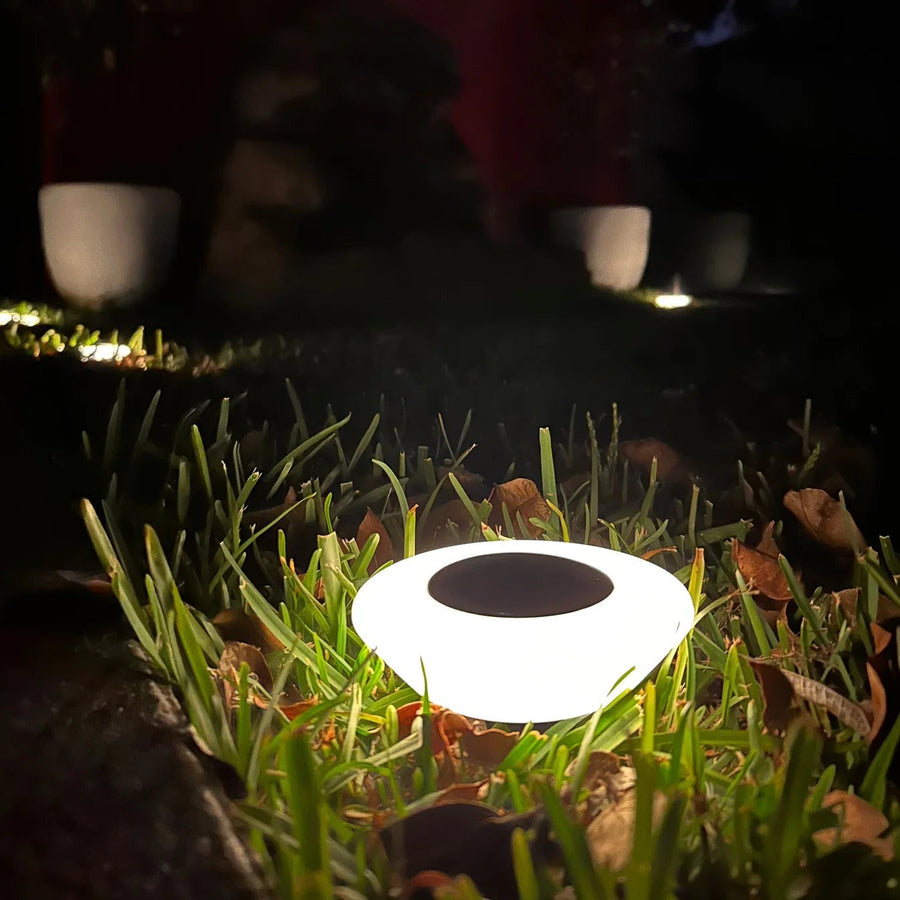 Solar ground light glowing in the lawn at night