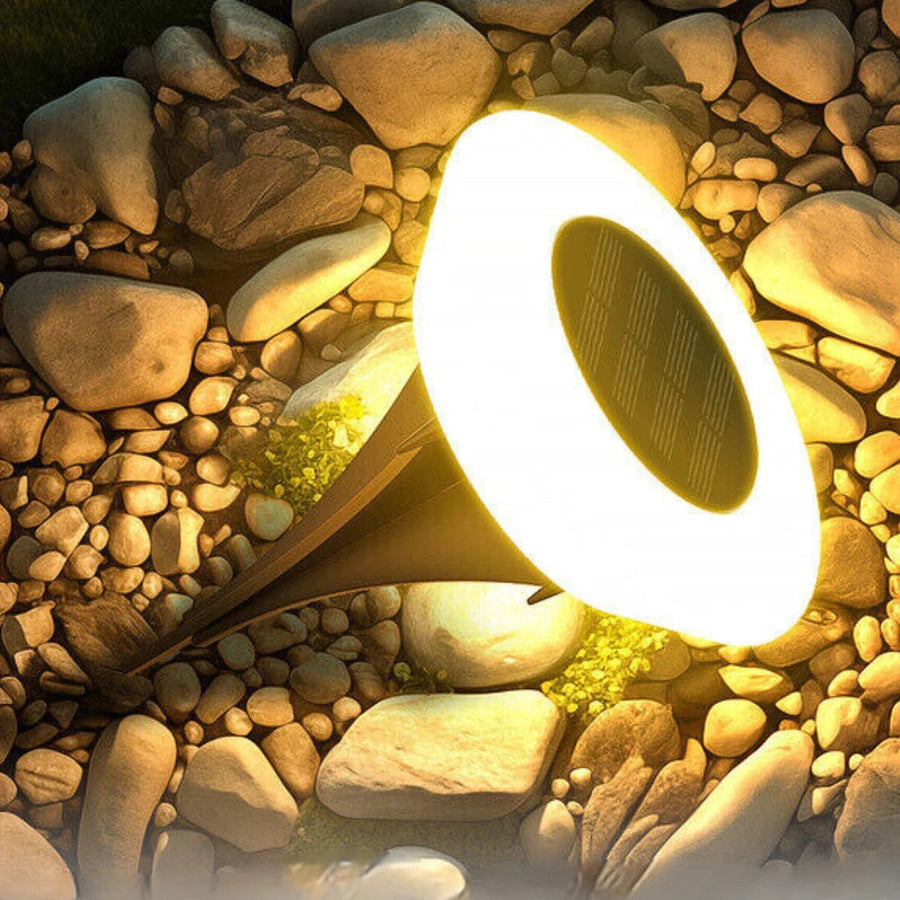 Close-up of a solar ground light with solar panel among stones