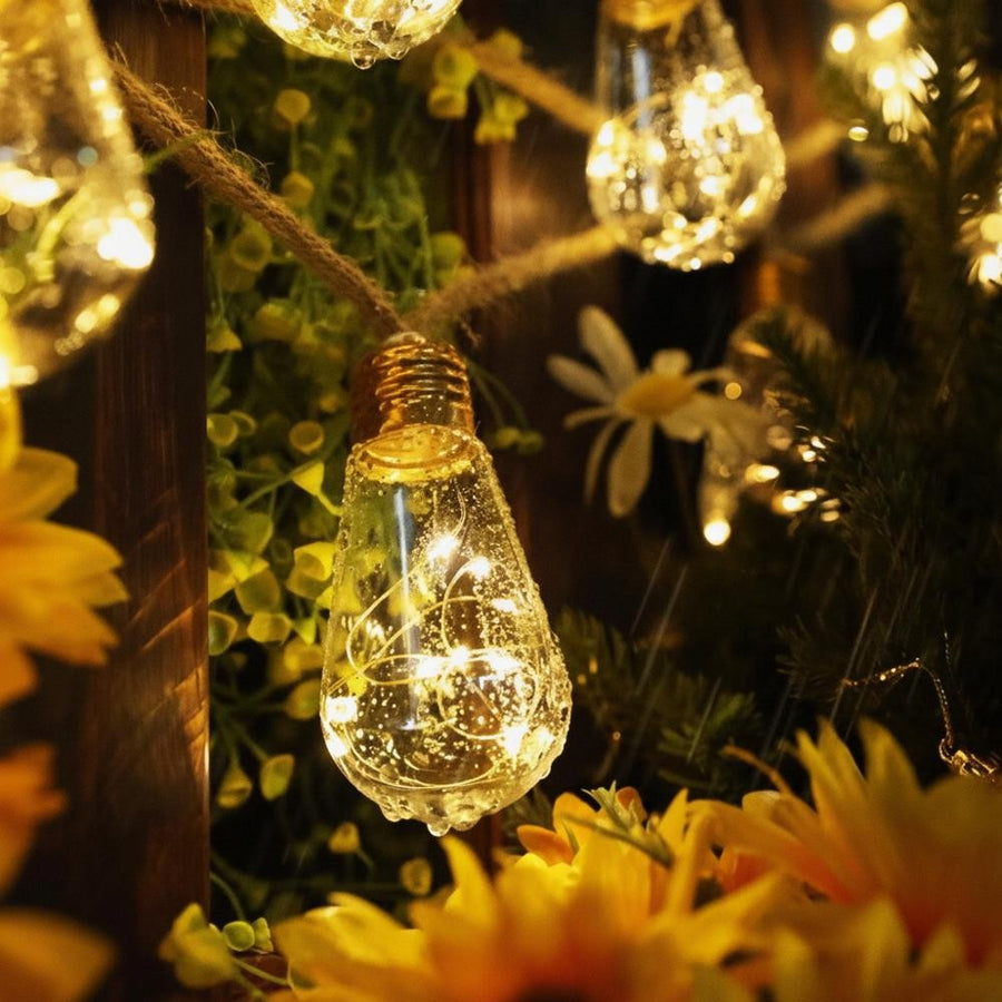 Close-up of an S17 bulb in hemp rope lights surrounded by flowers, IP65 waterproof