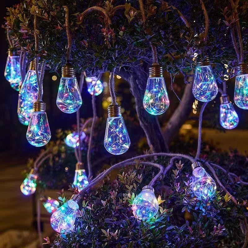 Multicolor solar hemp rope string lights hanging in a tree at night