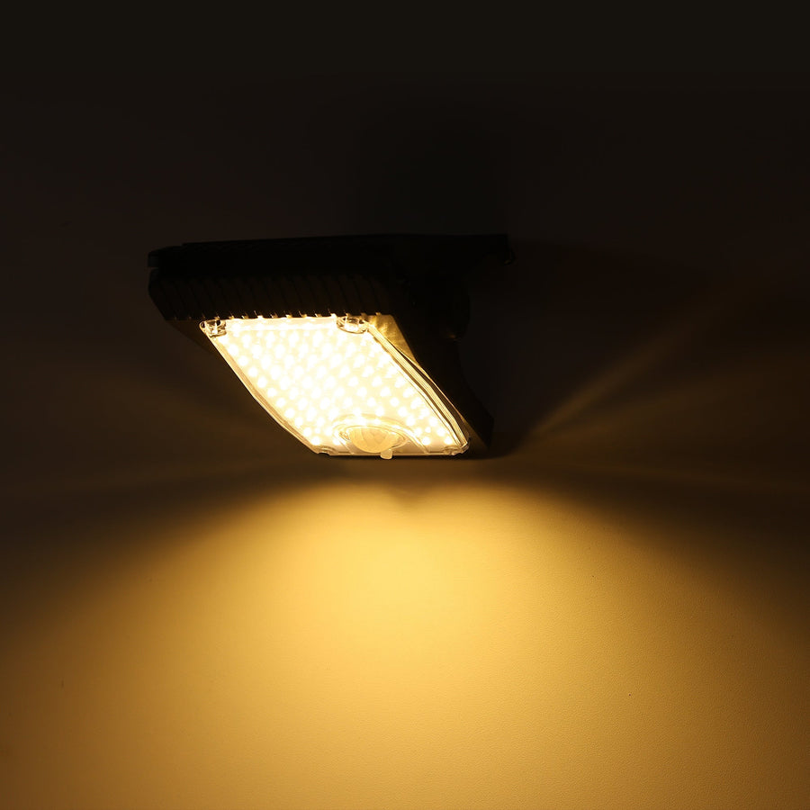 Solar light clipped to a fence, glowing warm white