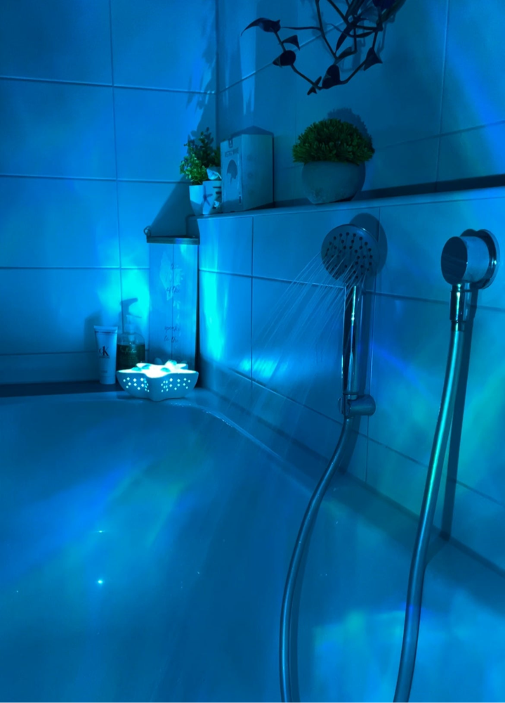 Starfish lamp casting blue wave light across bathroom tile