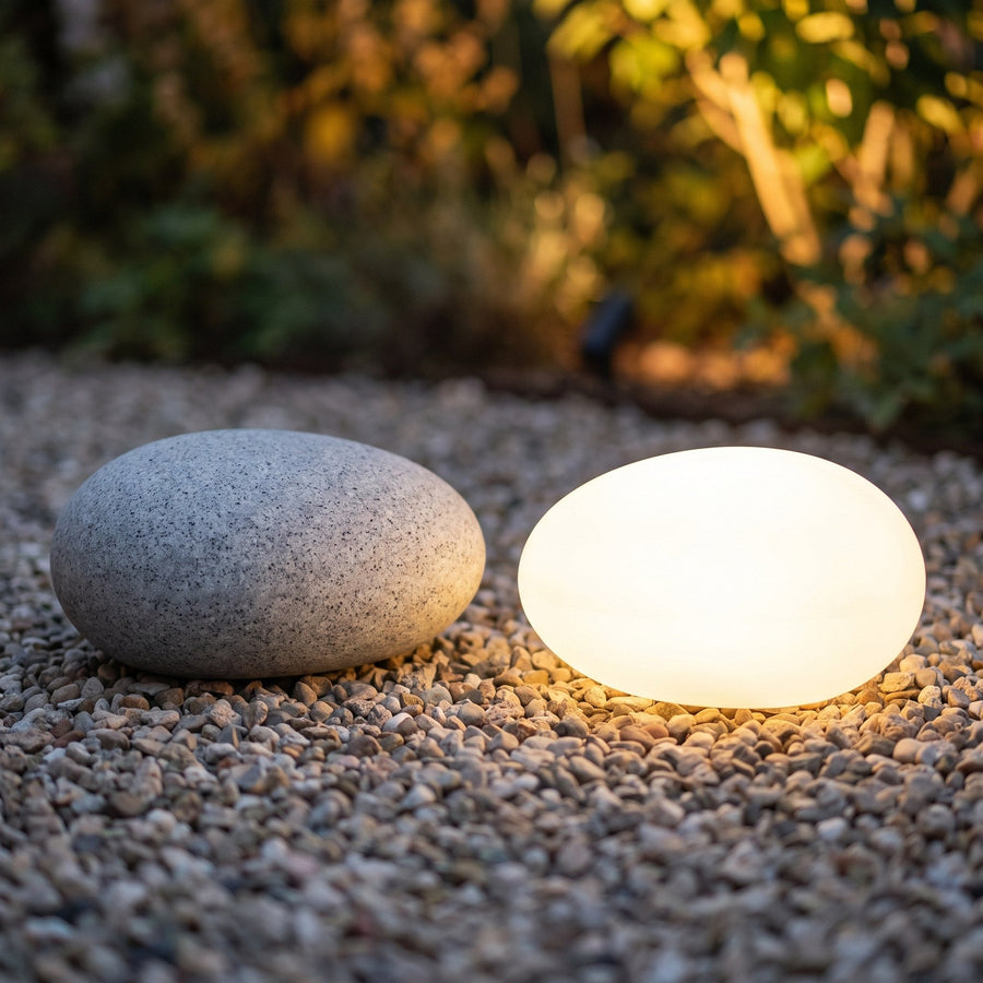 Unlit and lit stone lamp side by side on gravel