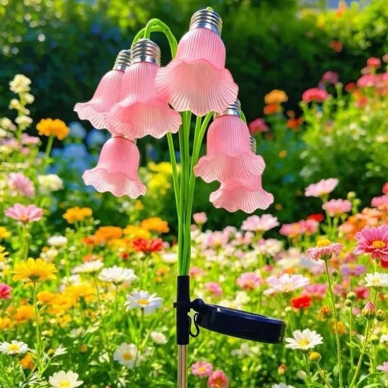 Pink solar flower stake lights in colorful garden