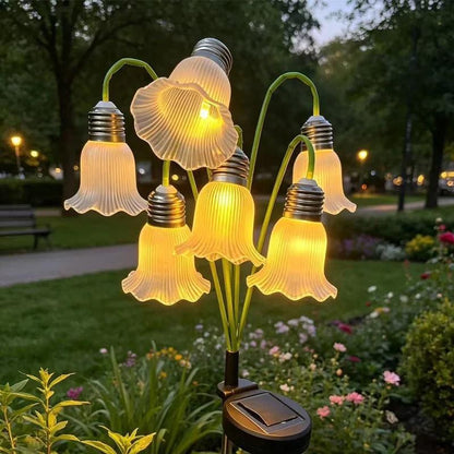 White solar flower lights glowing warmly at dusk in park