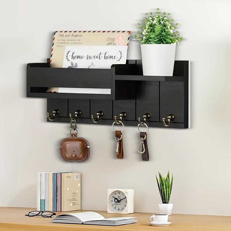 Black wall-mounted mail organizer with hooks and shelf